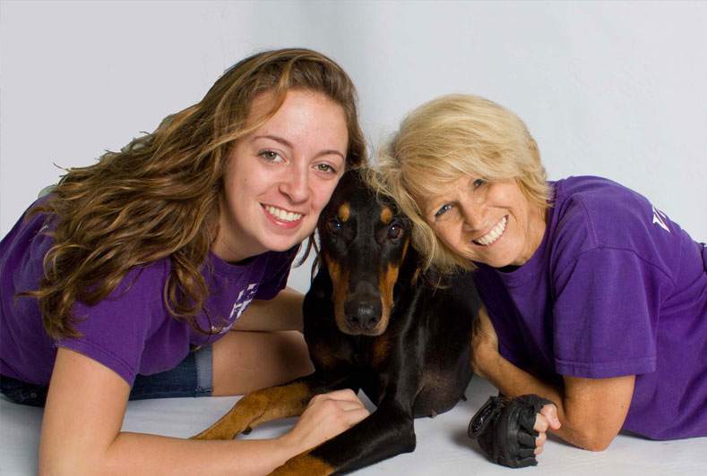 Two people posing with their puppy